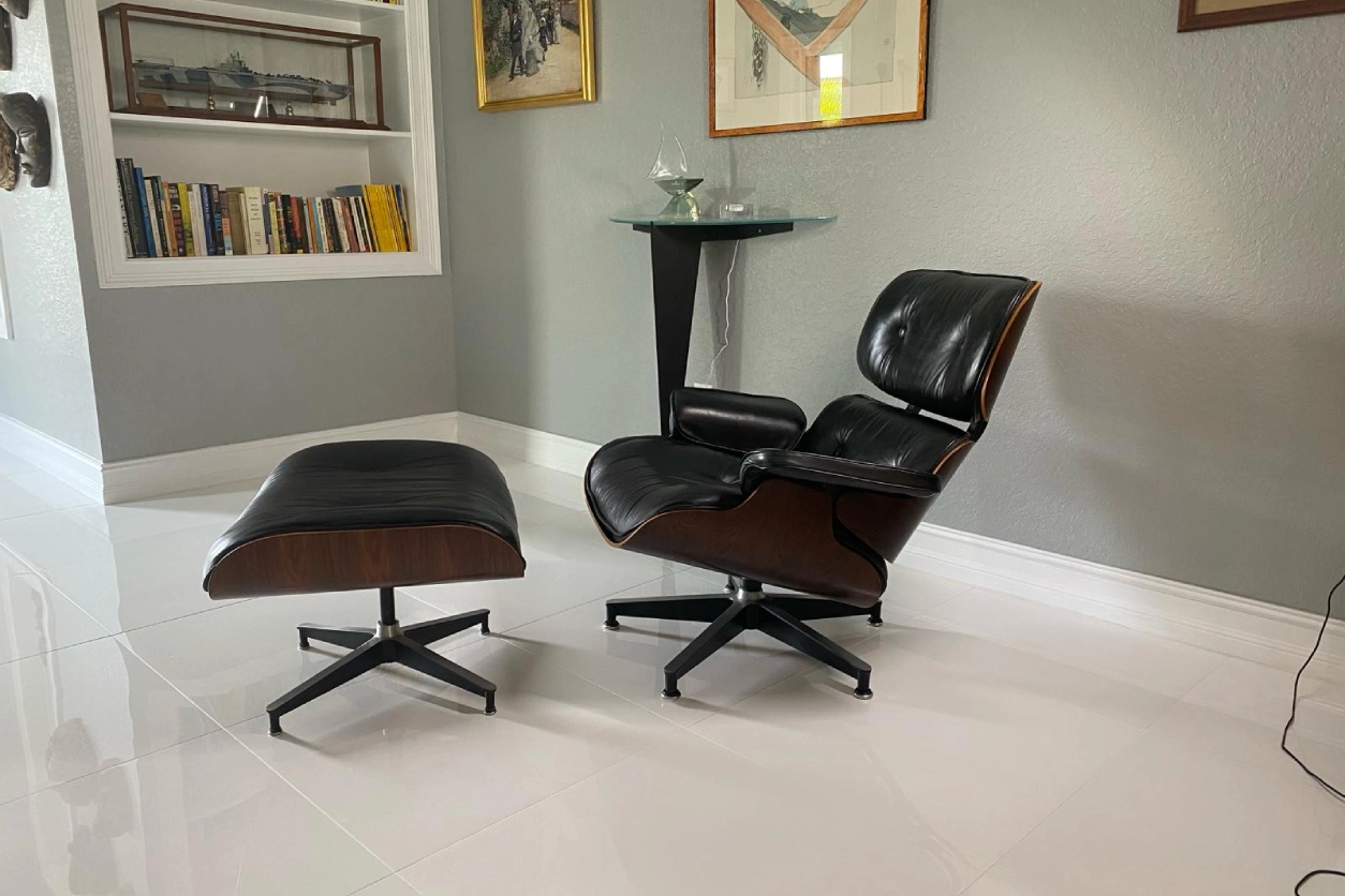 A chair and ottoman in the corner of a room.