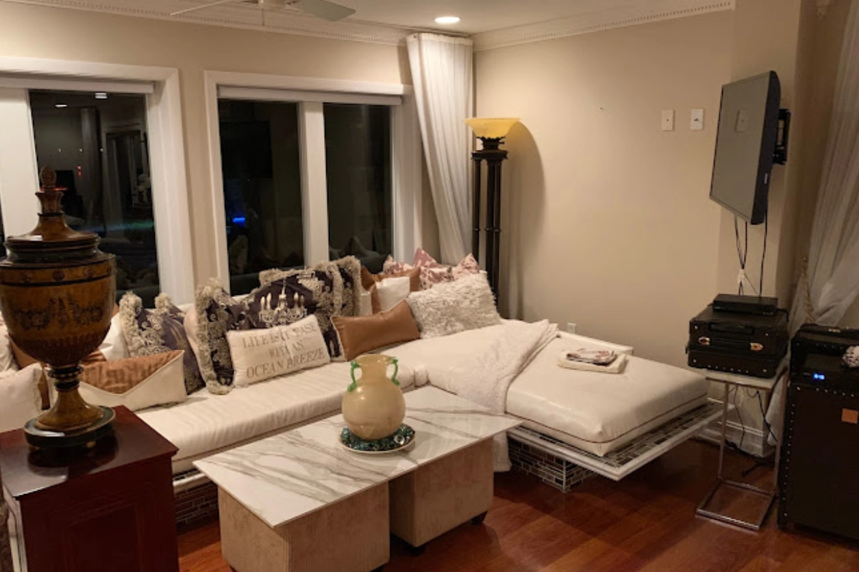 A living room with white furniture and wooden floors.