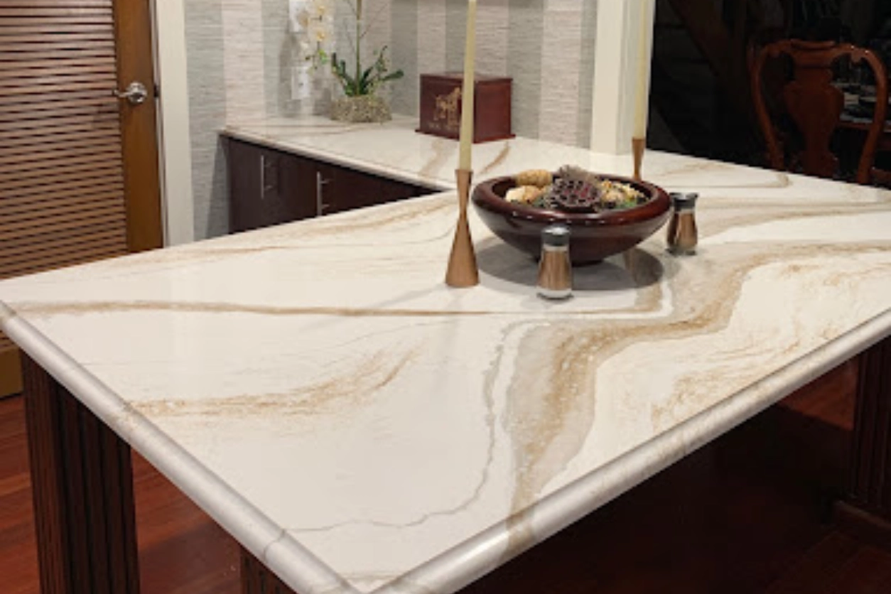 A marble counter top with candles and a bowl of fruit.