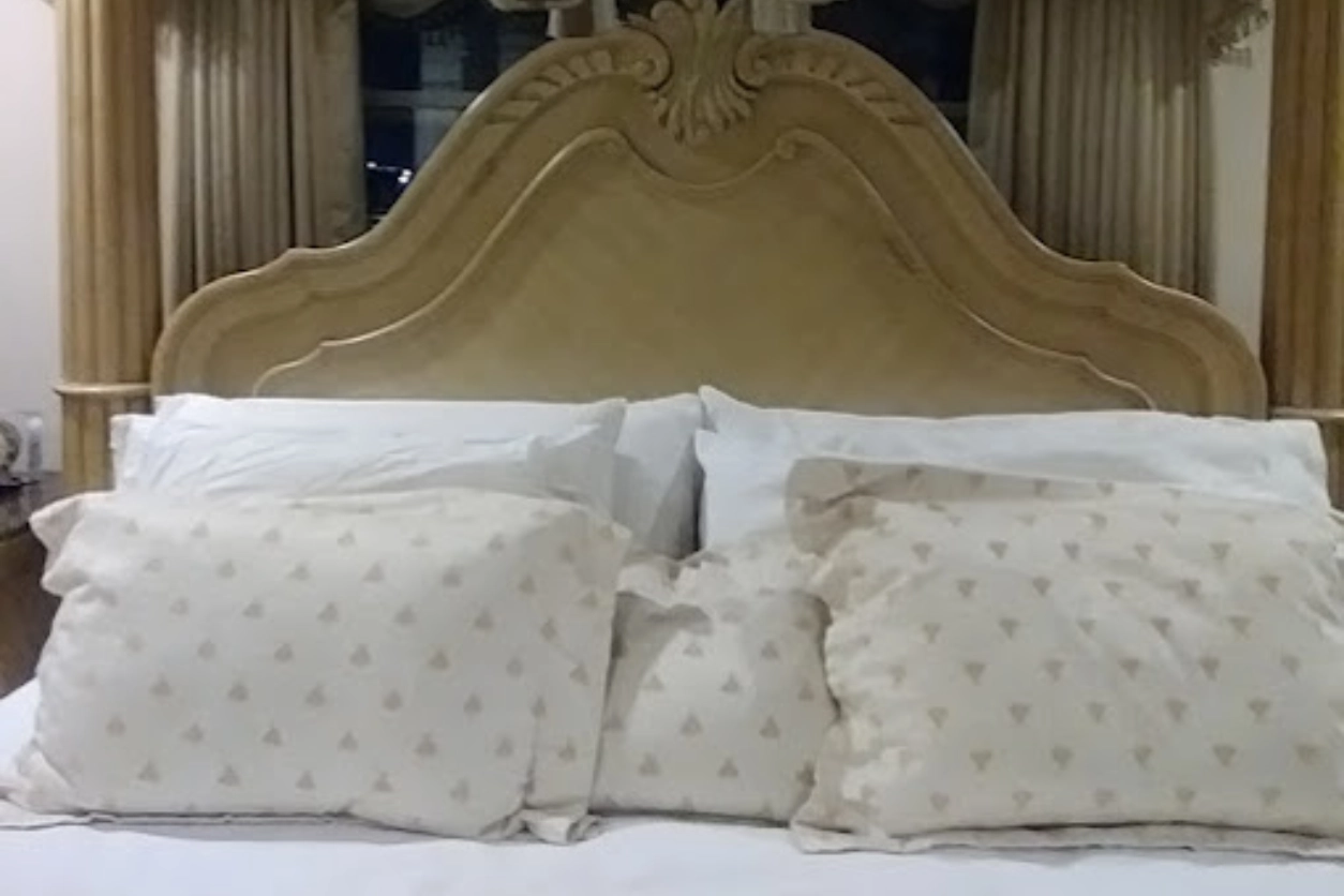 A bed with white sheets and pillows on it