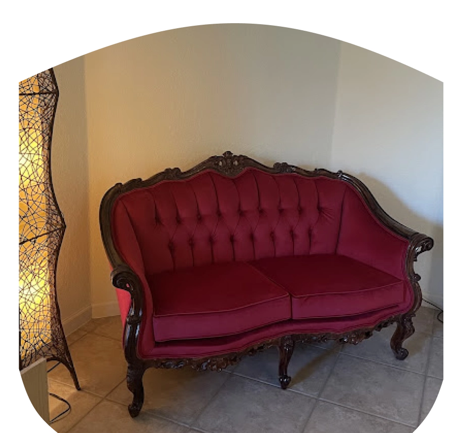 A red couch sitting in the corner of a room.